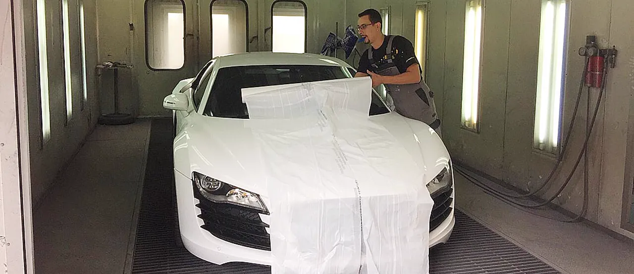 Kire maskerer en hvid Audi R8 inde i sprøjtekabinen